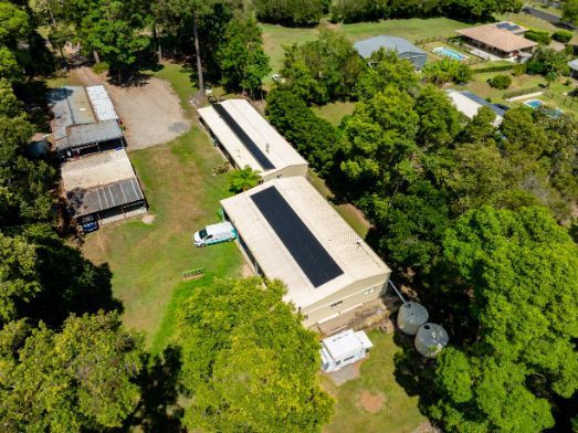 Workers Installing Solar Panels on A Curved Metal Roof — OzEnergi in Caloundra West, QLD