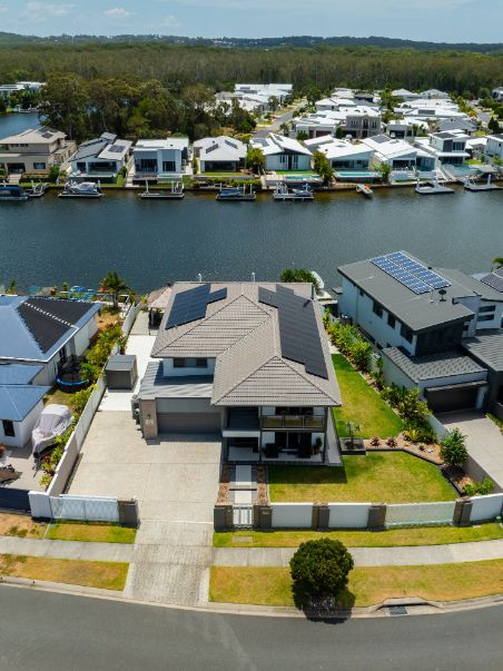 Solar Panels and Wind Turbine Under an Orange Sunset Sky — OzEnergi in Caloundra West, QLD