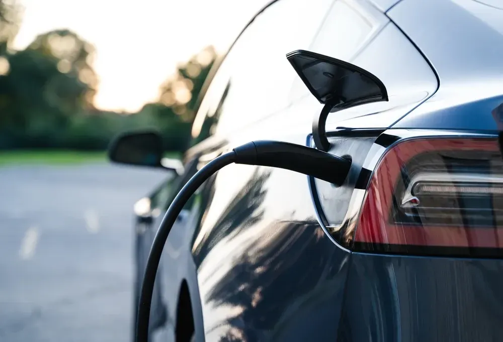Dark blue electric car charging, black charging cable connected. — OzEnergi in Yatala, QLD