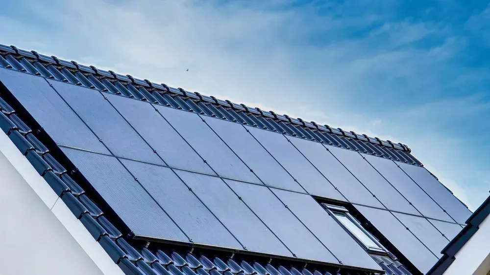 Solar panels on a tiled roof against a blue sky. — OzEnergi in Yatala, QLD