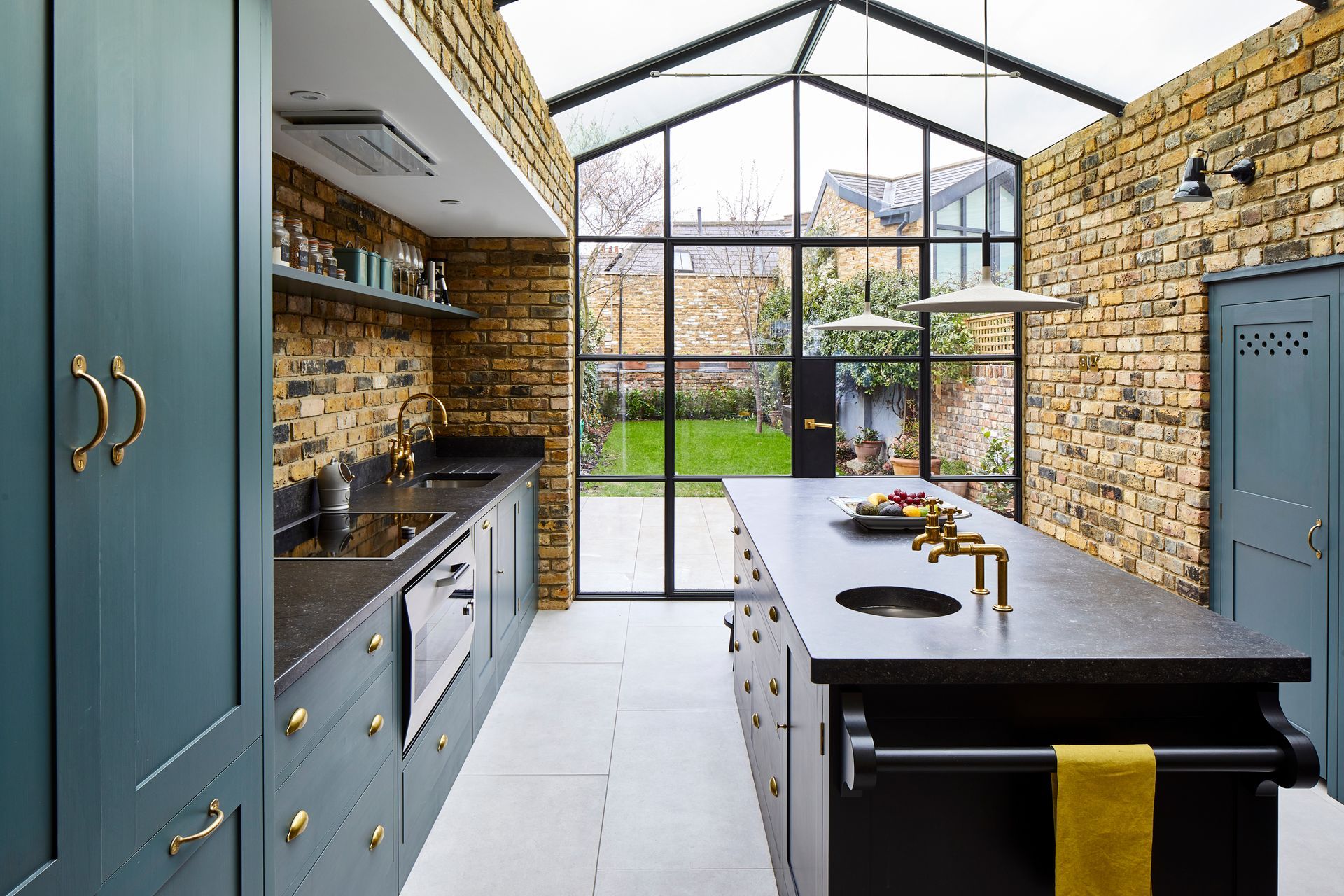 View of a home extension design showcasing a kitchen with teal cabinets.