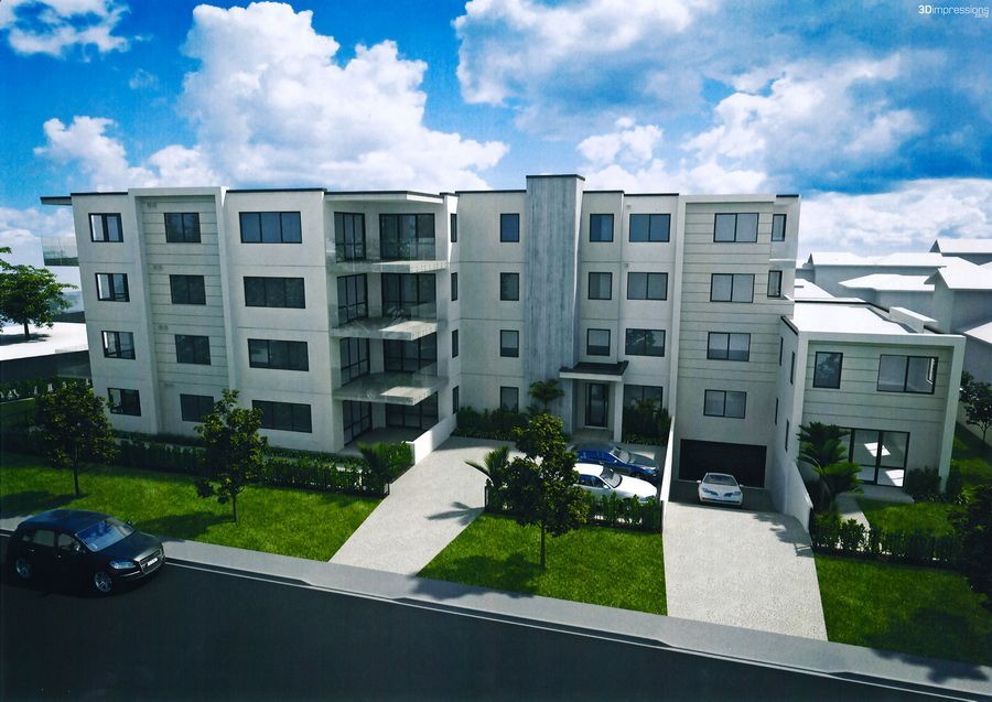 Modern multi-story apartment building with white exterior and attached garages on a sunny day.