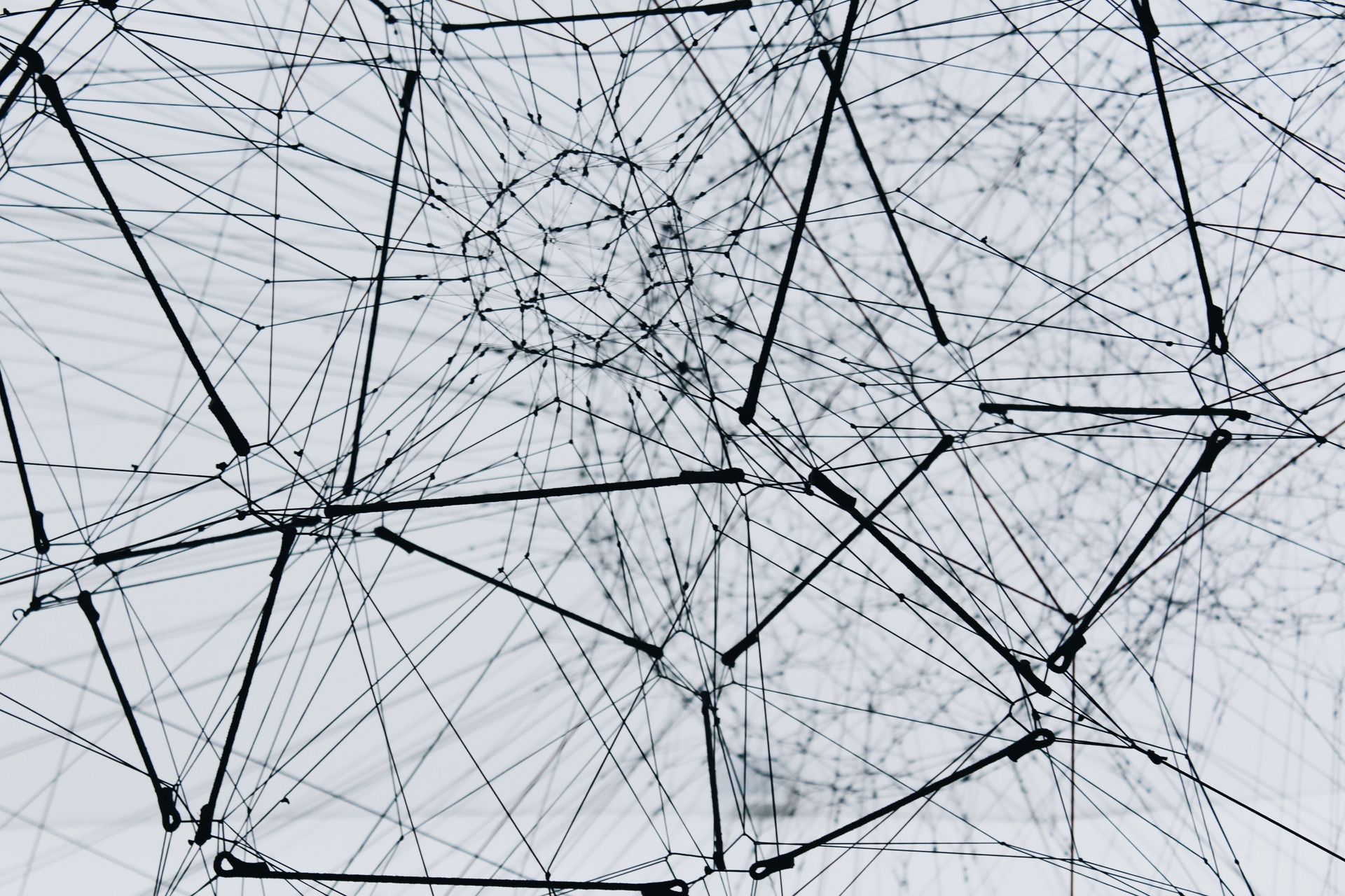 Interconnected network of lines and nodes against a pale background.