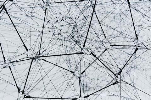 Abstract network of interconnected lines and nodes on a light background.