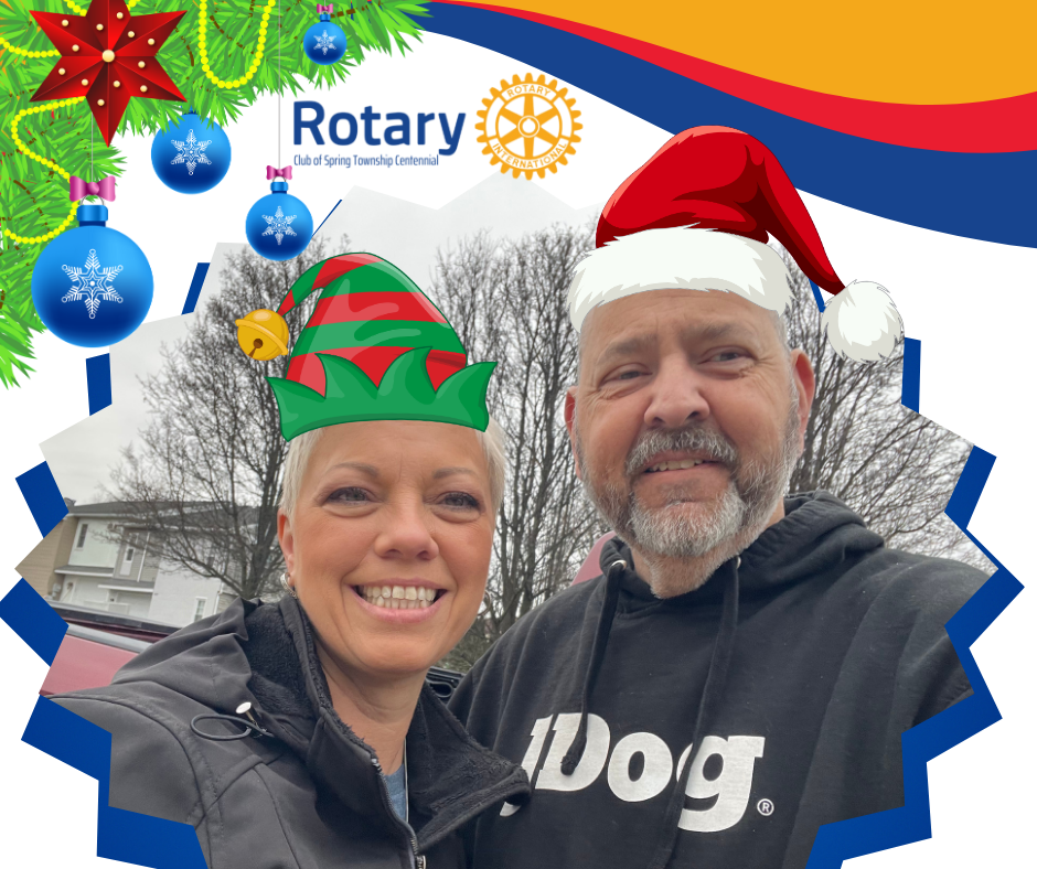 A man and woman wearing santa hats and a shirt that says dog