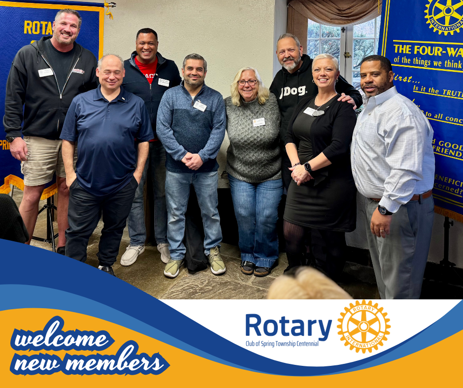 A group of people are standing in front of a banner that says welcome new members