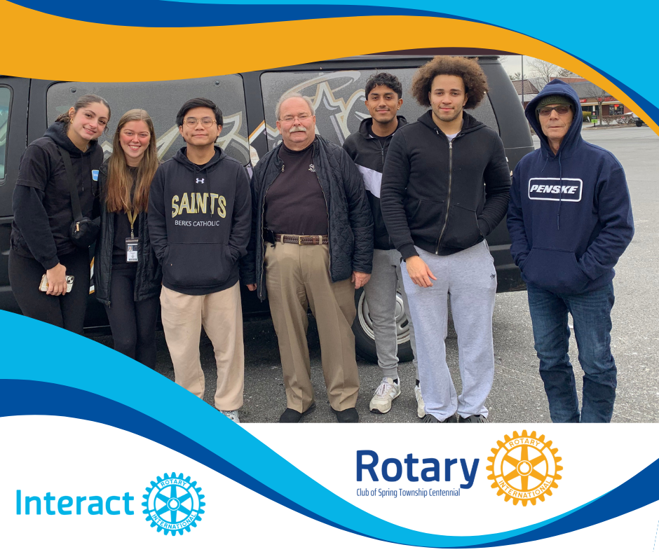 A group of people standing in front of a van that says saints on it