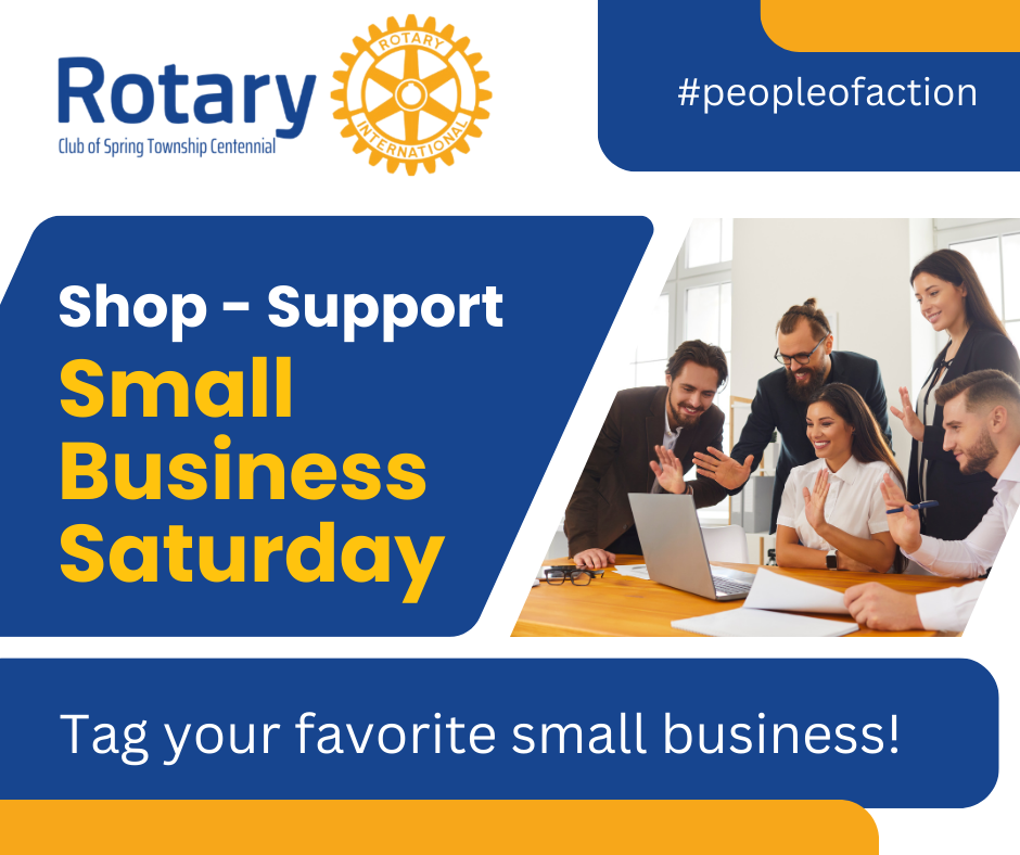 A group of people are sitting around a table with a laptop.