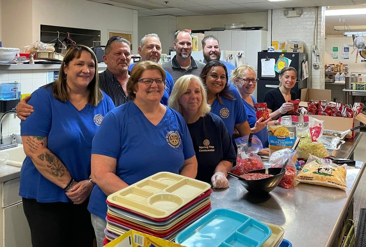 A group of people are posing for a picture in a kitchen.