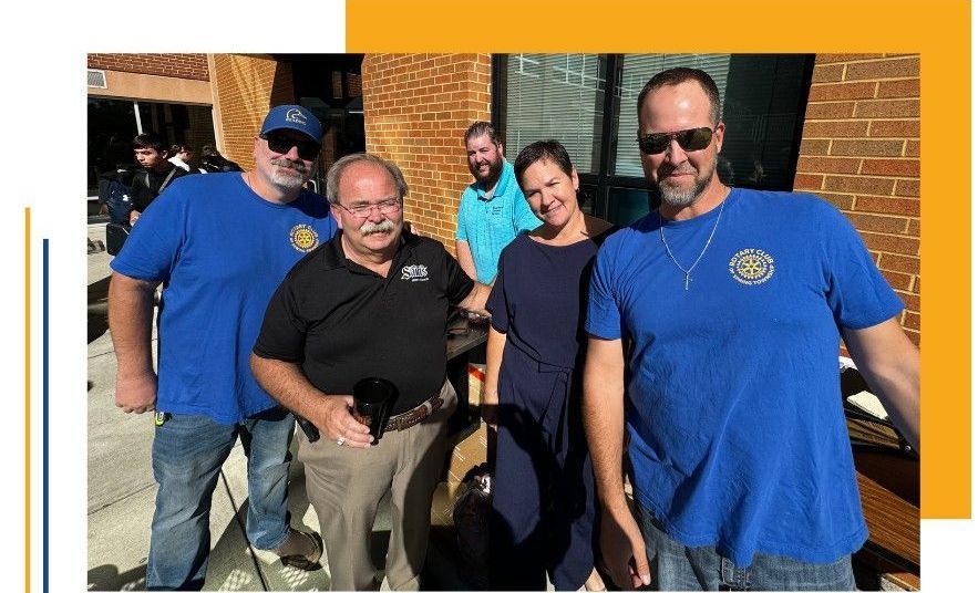 A group of people standing next to each other in front of a brick building.