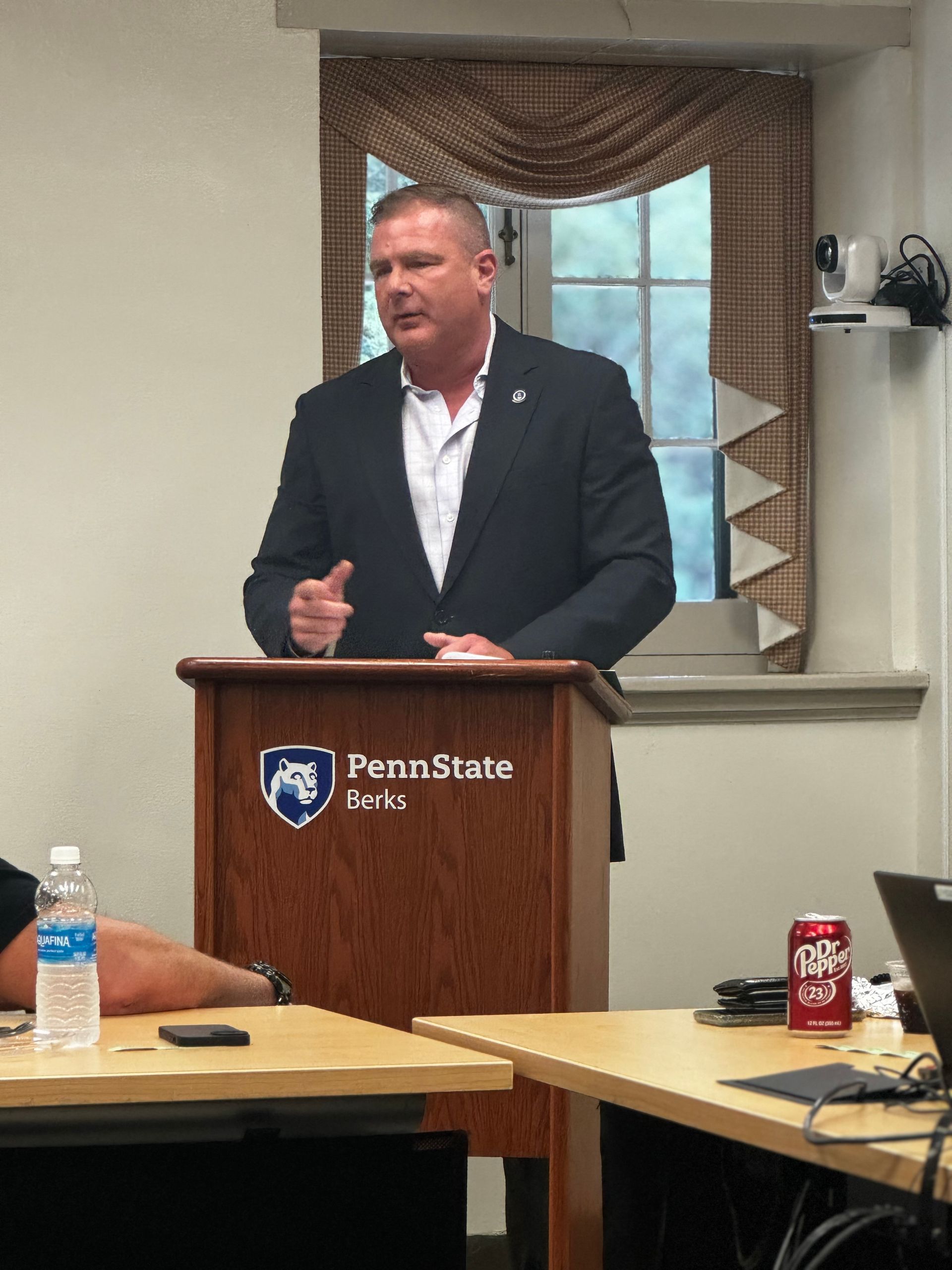 A man stands at a podium that says penn state