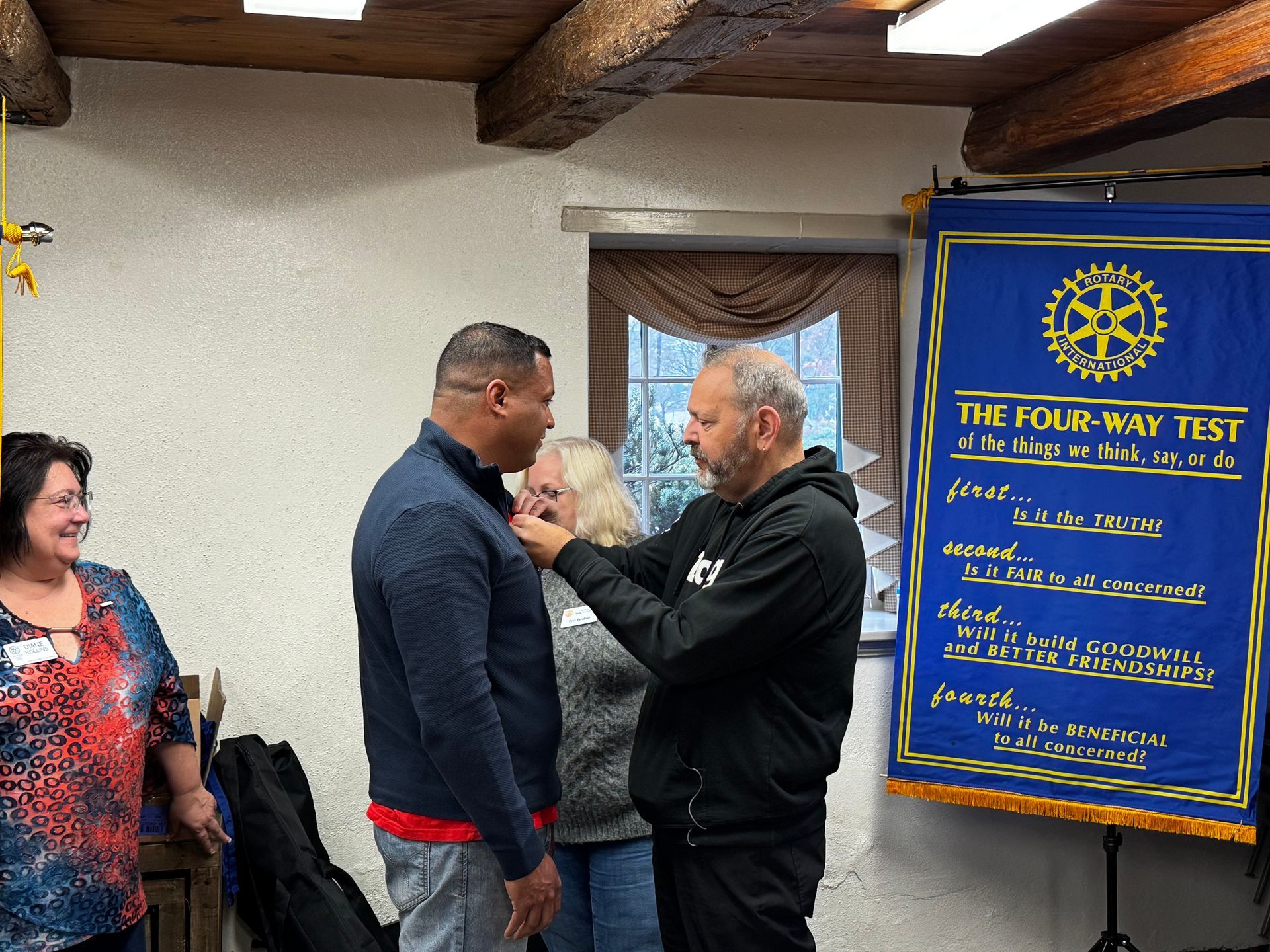 A group of people standing in front of a sign that says the four way test