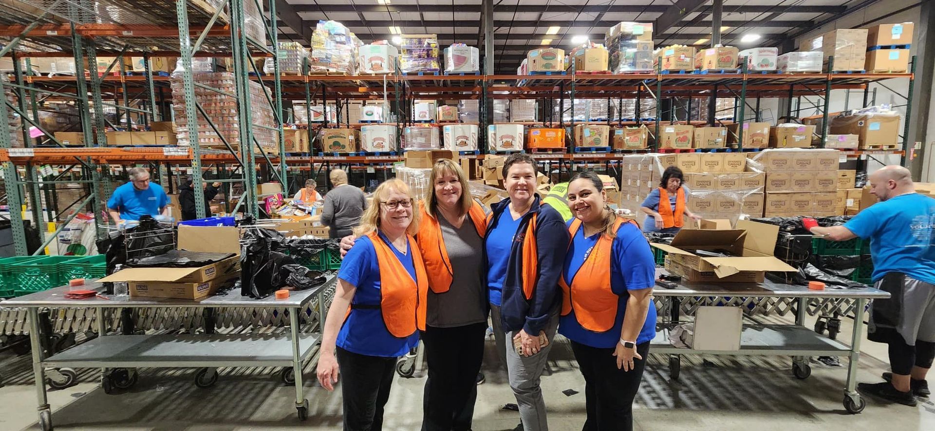 A group of women are posing for a picture in a warehouse.