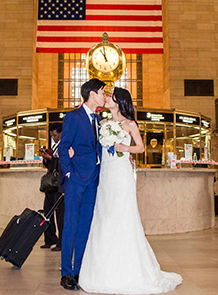 The bride and groom kissing with USA flag at the back