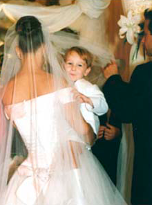 The bride in her wedding dress and carrying her son