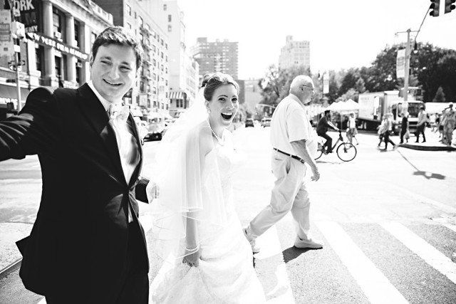Black and white photo of the bride and groom while crossing the street