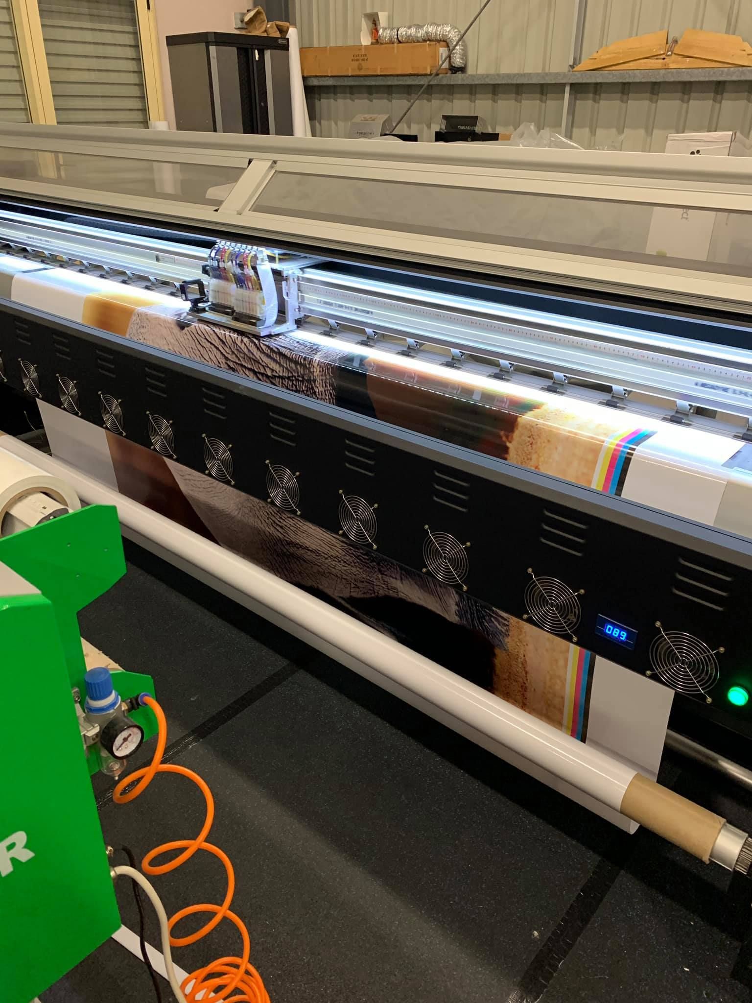 A large printer is printing a large piece of paper. - Plastiglass Mid North Coast, NSW