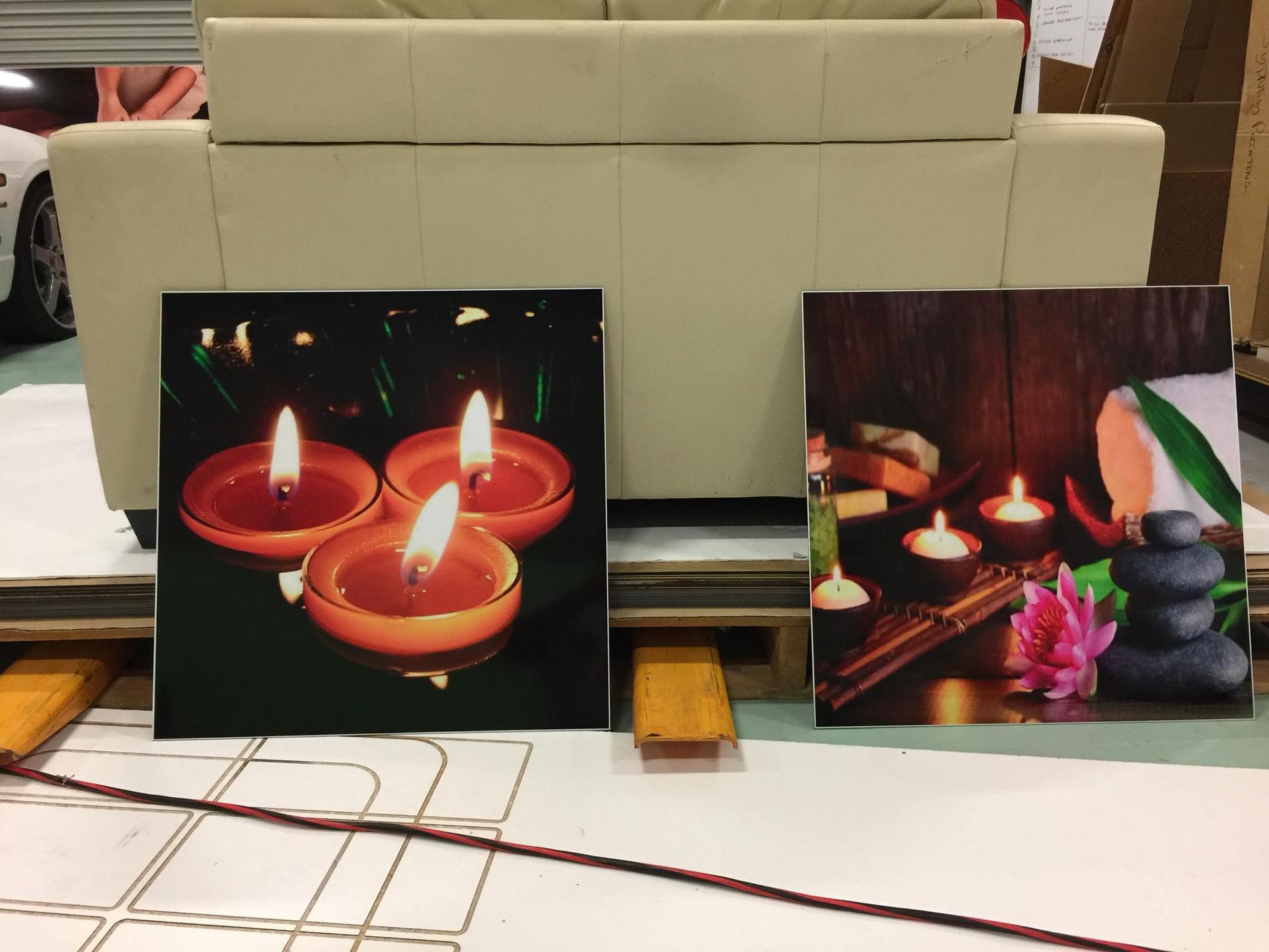 Two paintings of candles are sitting on a table in front of a couch - Plastiglass Mid North Coast, NSW