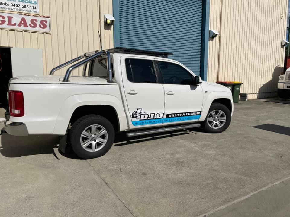 A white truck is parked in front of a building that says plastiglass - Plastiglass Nabiac, NSW
