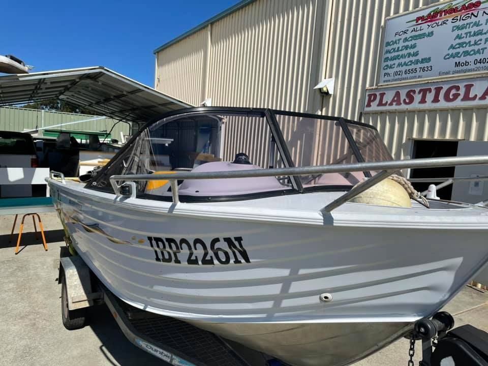 A white boat is parked in front of a building.