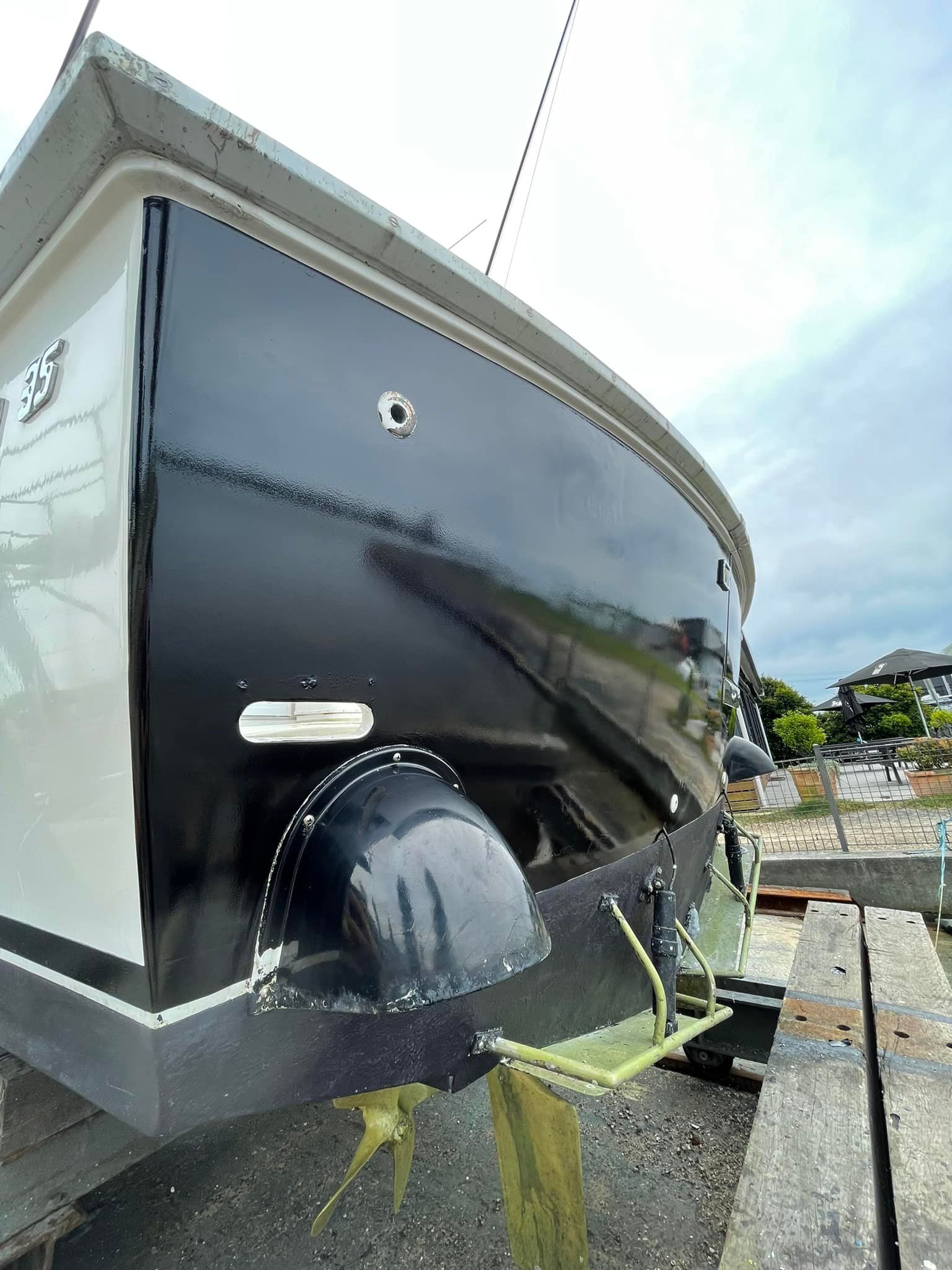 A black and white boat is getting wrapped - Plastiglass Nabiac, NSW