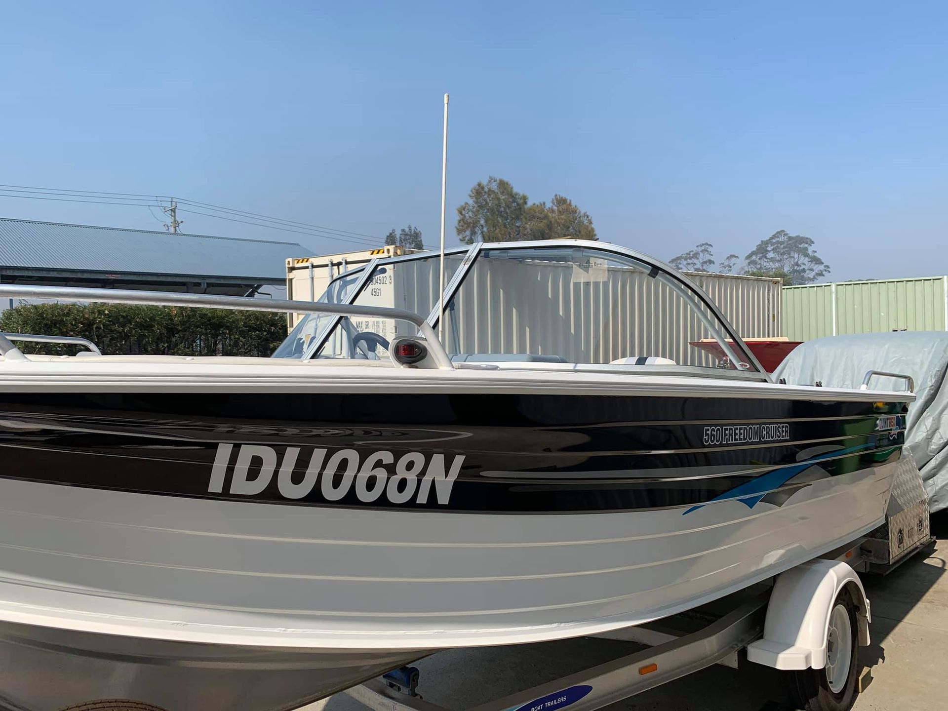 A boat with the number idu068n on the side is parked on a trailer.