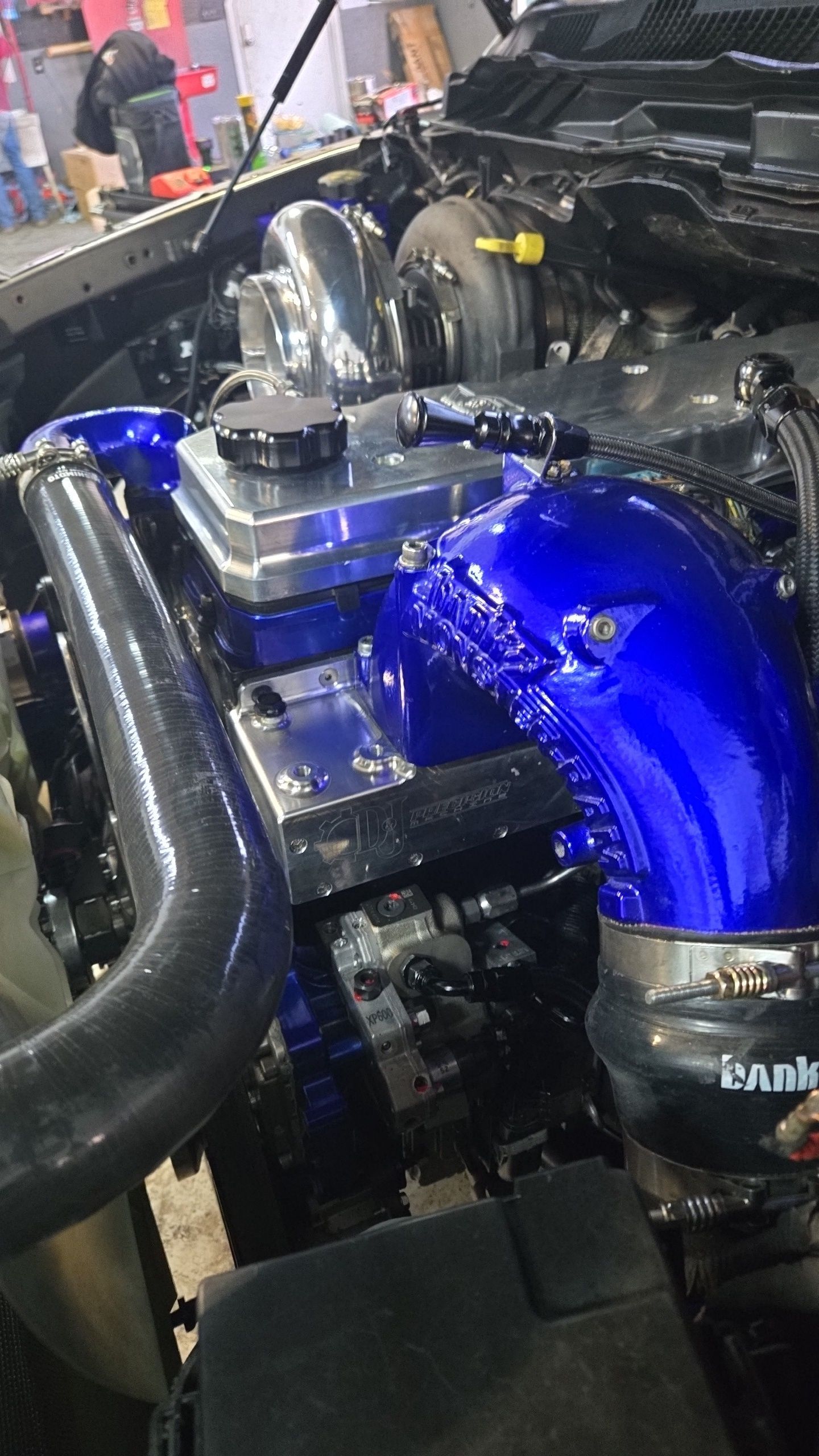 A blue hose is attached to the engine of a car.