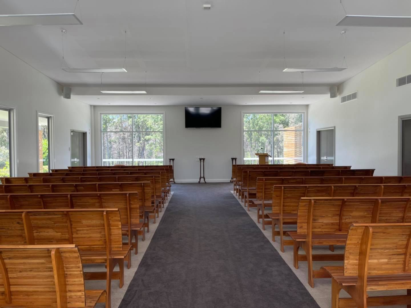 There Are Rows Of Wooden Benches In A Church — United Funeral Care In Kempsey, NSW
