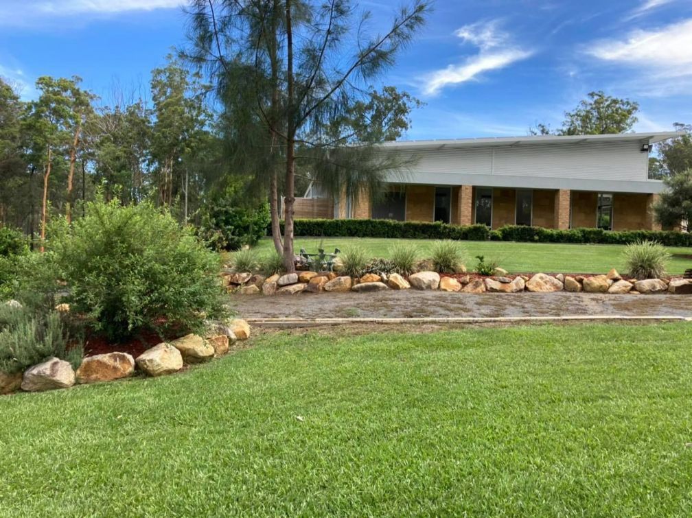 A large house with a lot of grass and rocks in front of it— United Funeral Care In Kempsey, NSW