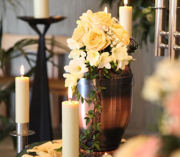 A Vase Filled With Flowers And Candles Is On A Table — United Funeral Care In Kempsey, NSW