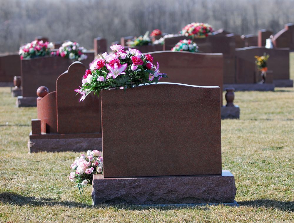 A Row Of Graves In A Cemetery With Flowers On Them — United Funeral Care In Frederickton, NSW