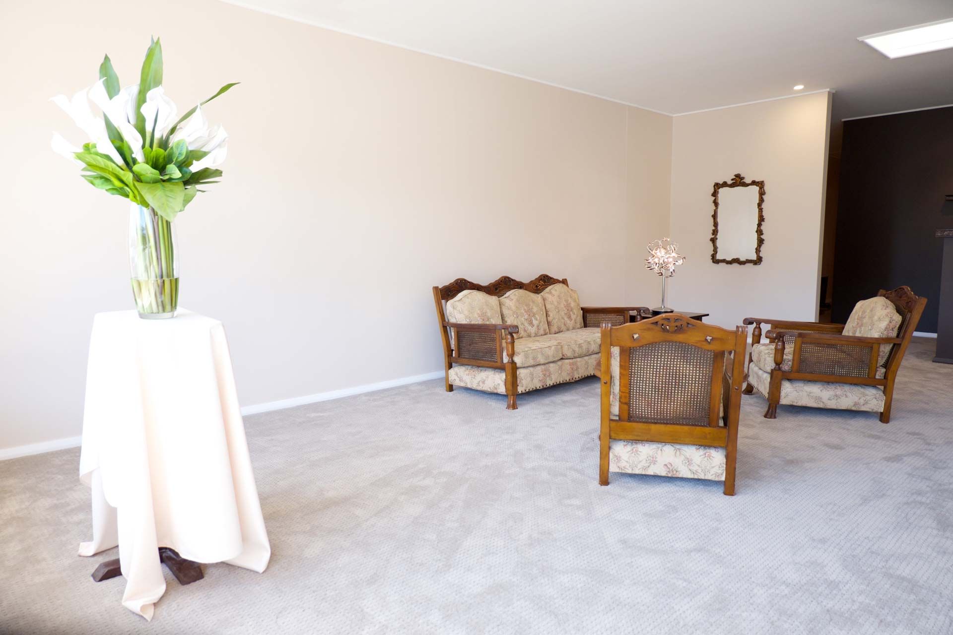 A Living Room With A Couch And Chairs And A Table With Flowers On It — United Funeral Care In Kempsey, NSW