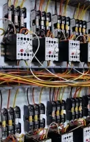 Rows of electrical relays and wiring in a control panel, with many colored cables and labeled components