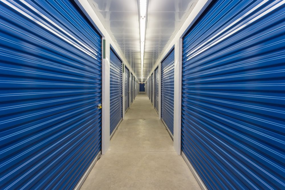 A Long Hallway With Blue Doors In A Storage Facility — Howlett's Mini Storage In Bundaberg East, QLD