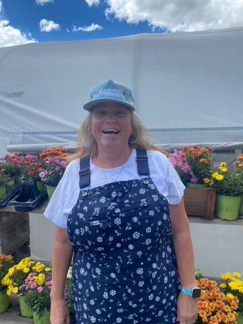 A woman with a braided ponytail is standing in front of a blue sky.