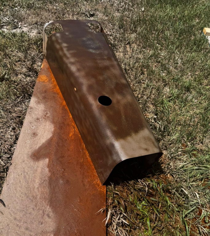 A piece of rusty metal with a hole in the middle