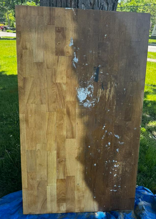 A piece of wood is sitting on top of a blue tarp.