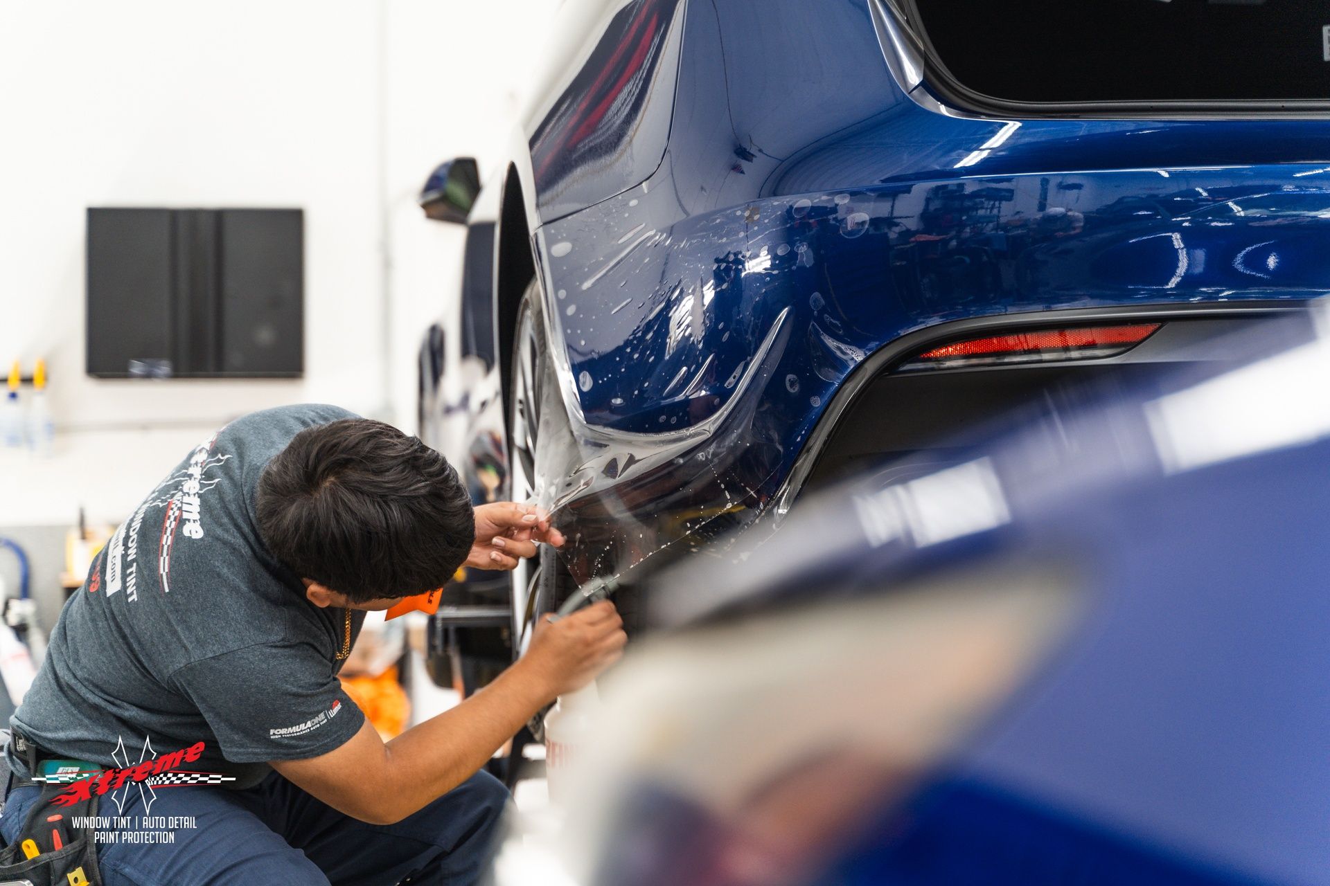 professional paint protection film installation on blue car