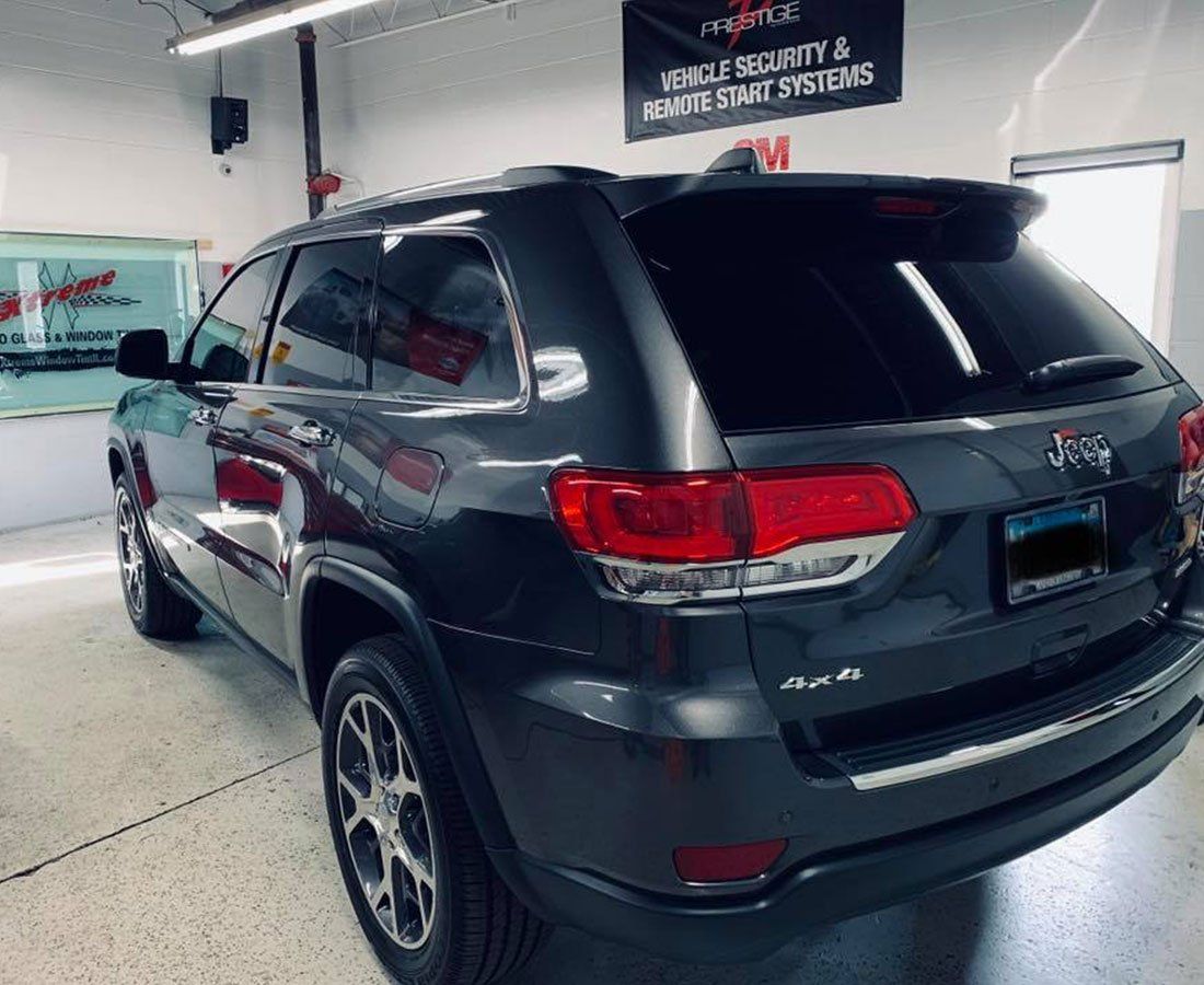 a gray jeep grand cherokee is parked in a garage .