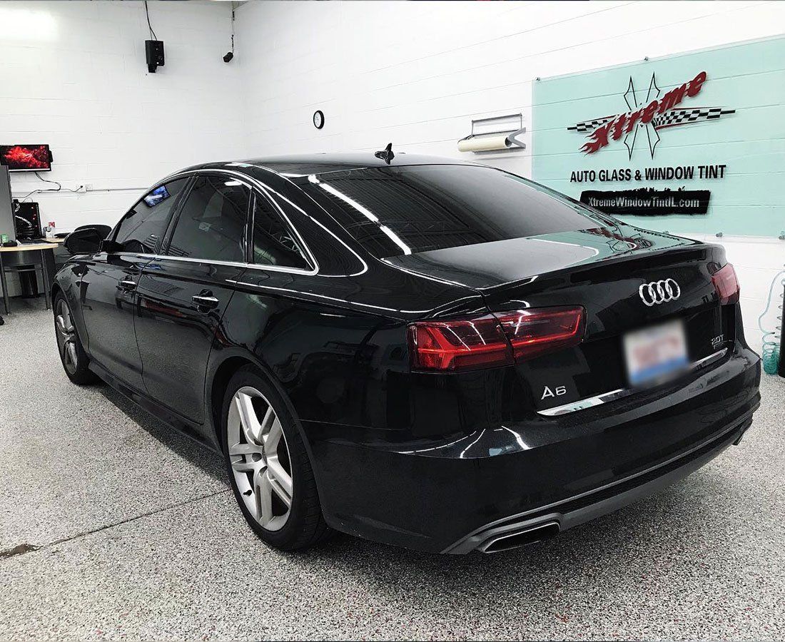 a black audi a6 is parked in a garage .