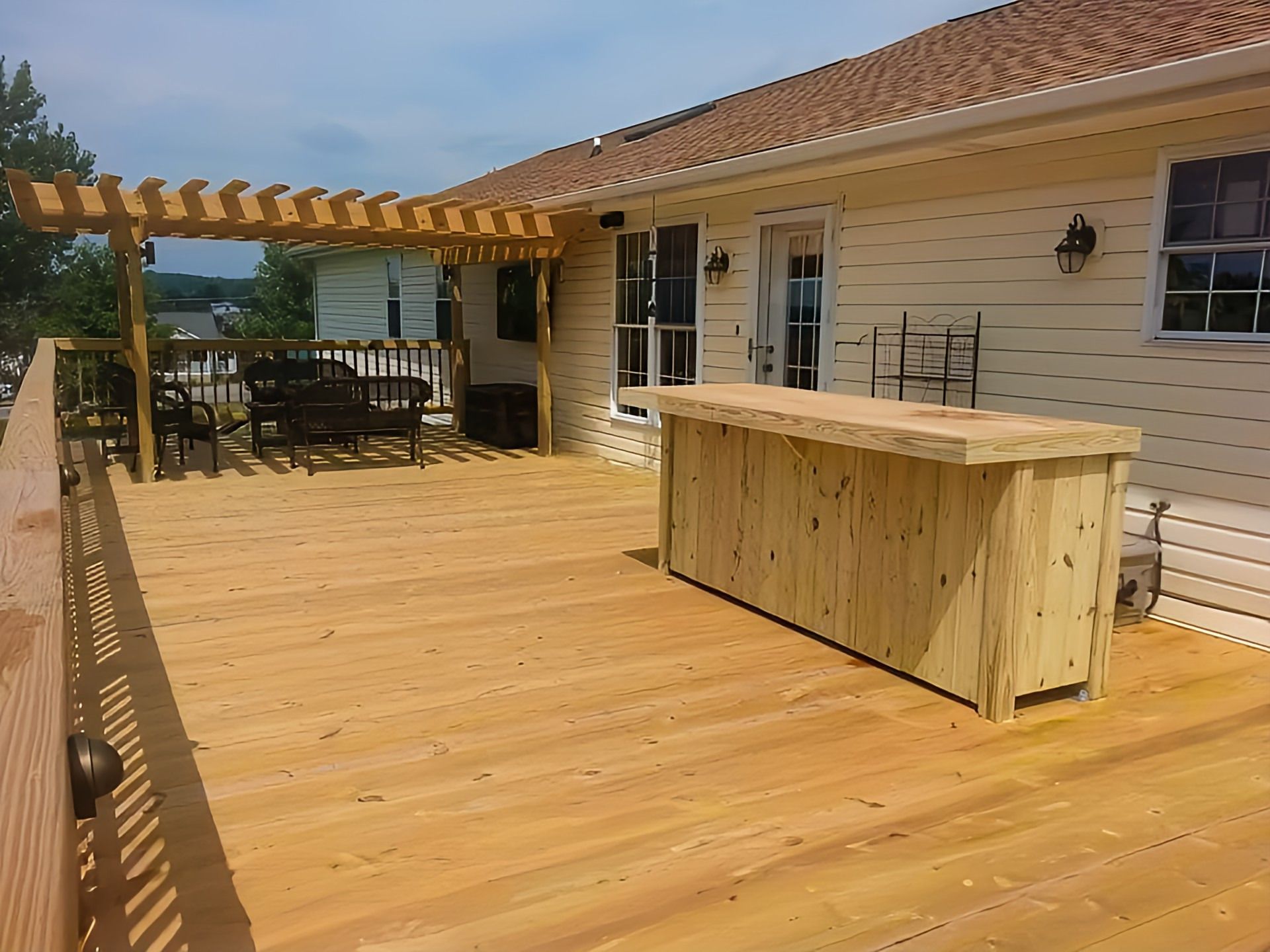 Beautiful backyard with a custom-built deck, patio, fence, and pergola by Red Beaver Construction.