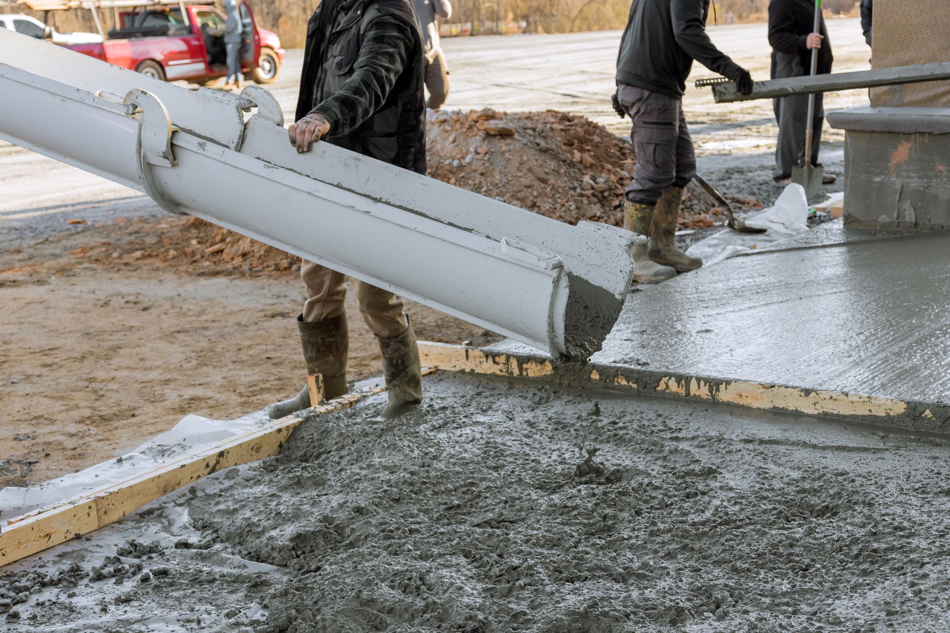 Red Beaver Construction workers pouring a concrete pad at a residential site.