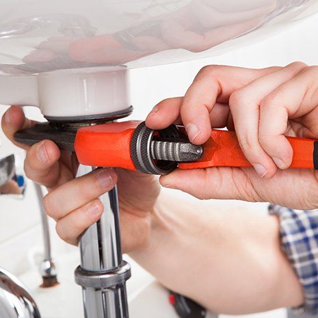 Male plumber fixing a sink in bathroom