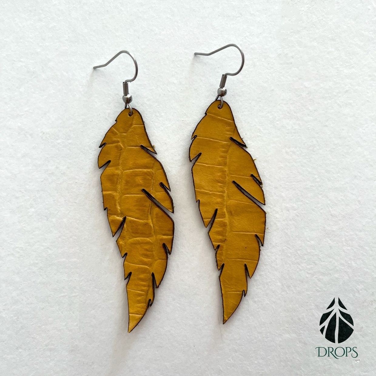 Un par de pendientes en forma de plumas hechos con gotas.