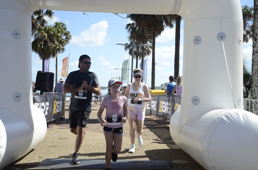 A Crowd Is Running Through An Inflated Archway Finish Line — Run Fest in Port Macquarie, NSW