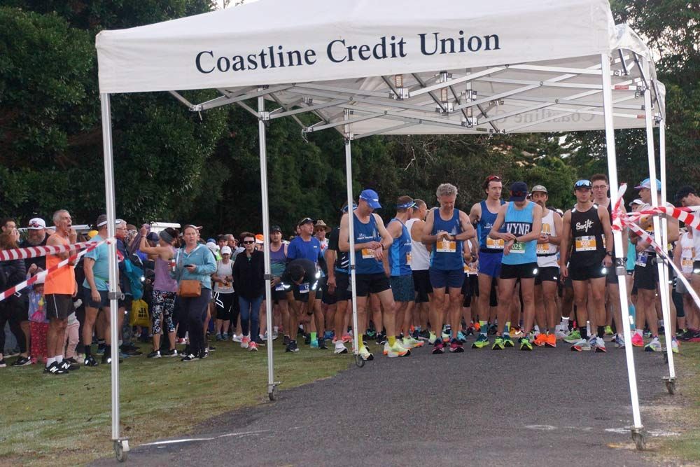 A Group Of People Are Standing Under A Canopy That Says Coastline Credit Union — Run Fest in South West Rocks, NSW
