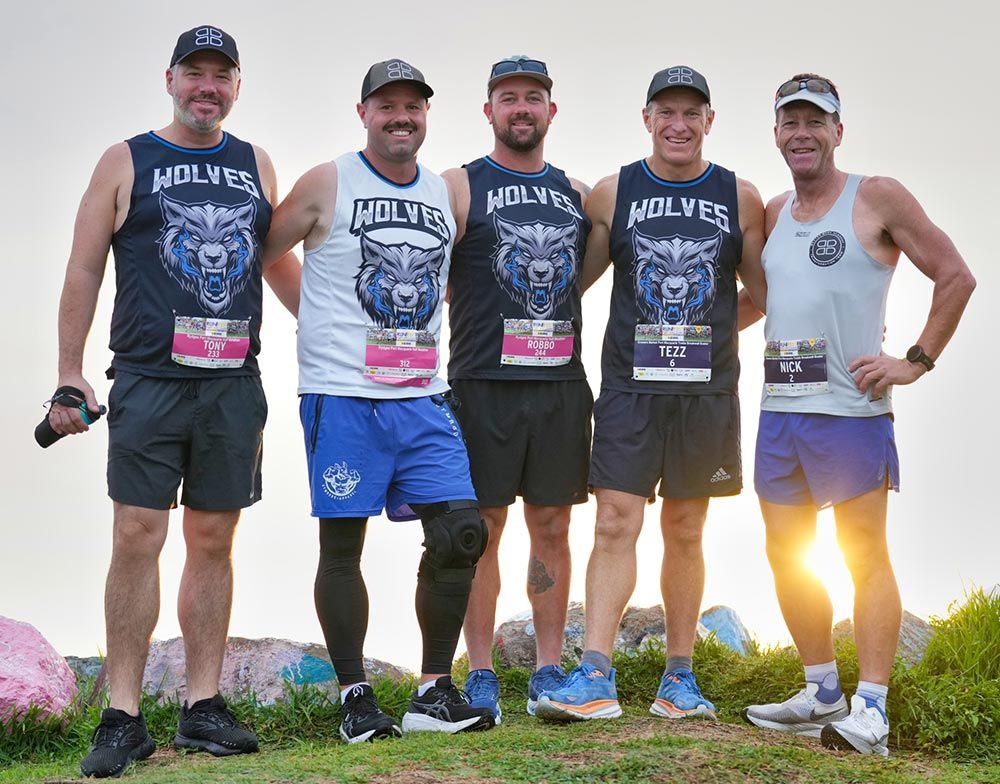 A Group Of Men Wearing Wolves Shirts Are Posing For A Picture — Run Fest in Port Macquarie, NSW
