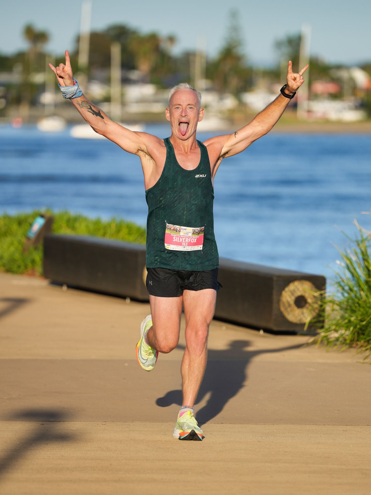 A Group Of Women In Pink Tank Tops And Shorts Are Standing In The Grass — Run Fest in Port Macquarie, NSW