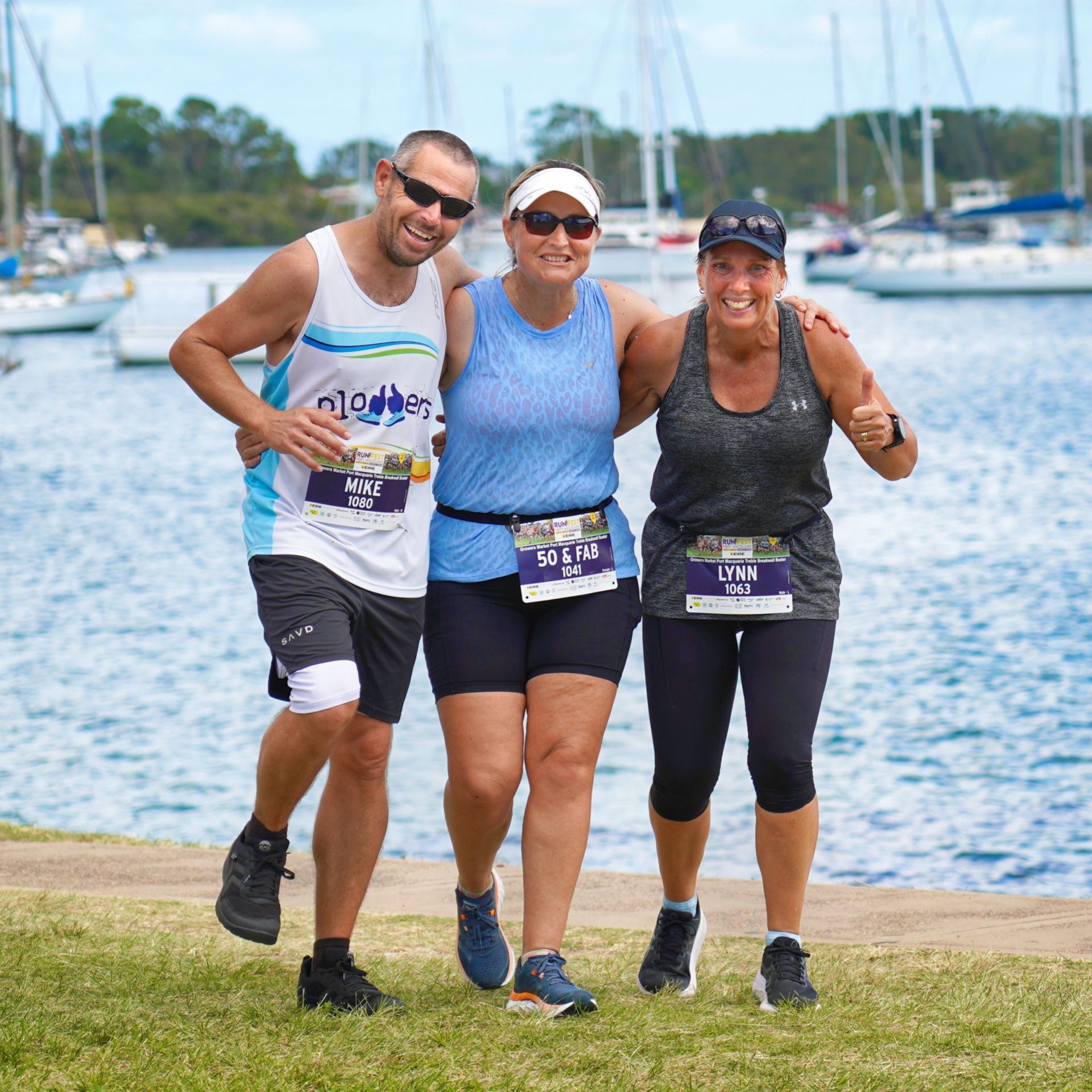 Two Women Are Standing Next To Each Other In Front Of A Wall Holding Backpacks — Run Fest in Port Macquarie, NSW