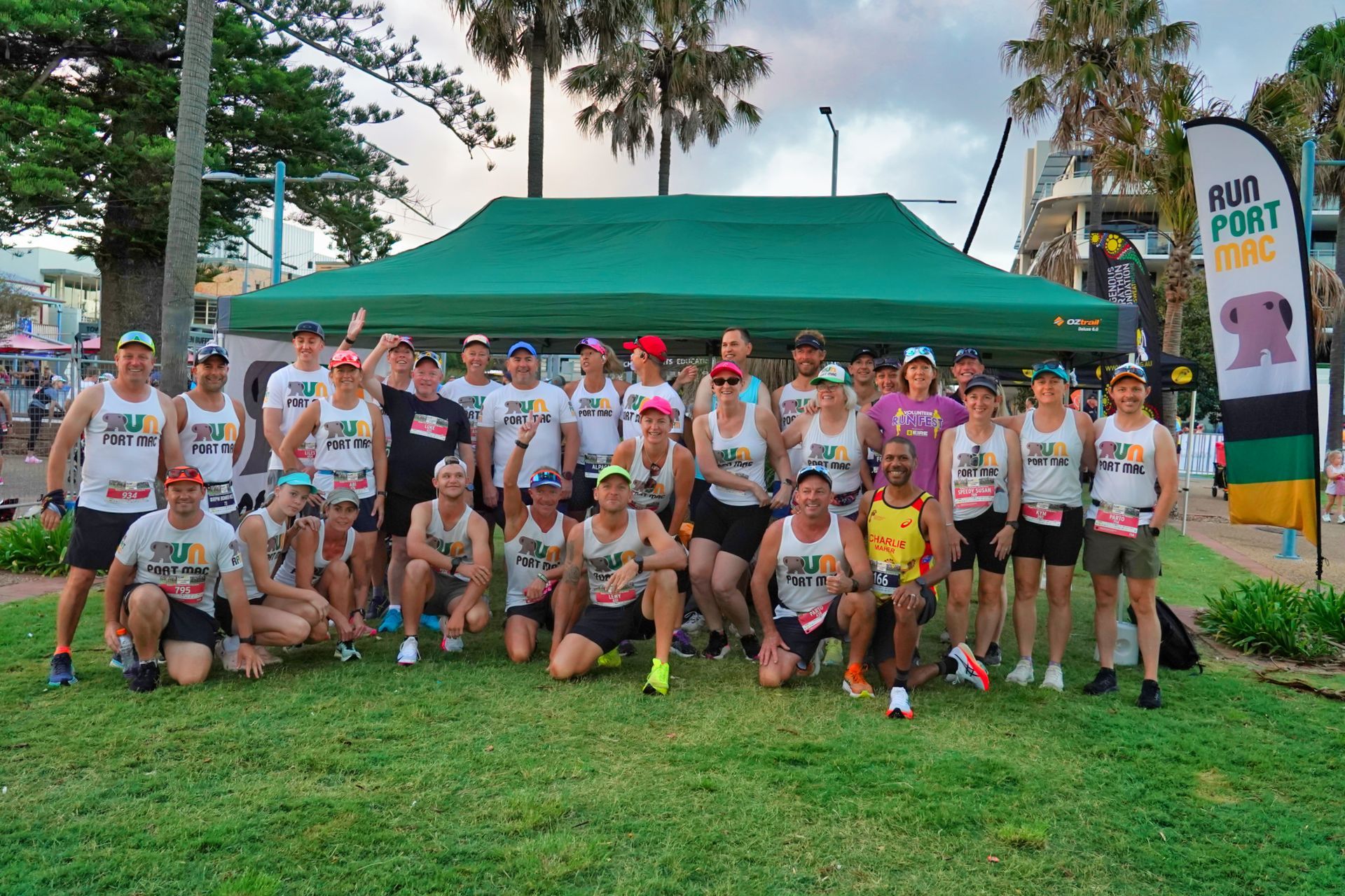 A Group Of People Are Running On A Sidewalk Near A Body Of Water — Run Fest in Port Macquarie, NSW